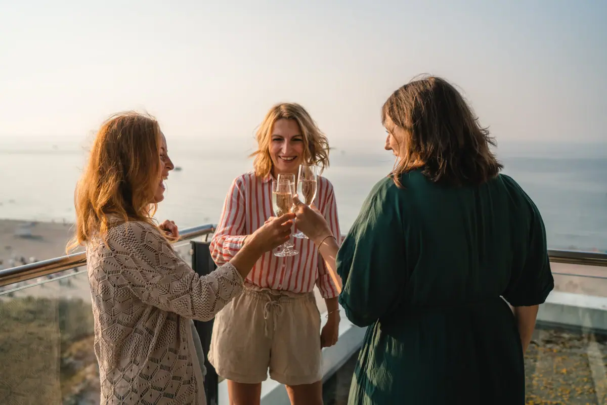 Een groep vrouwen houdt wijnglazen vast.