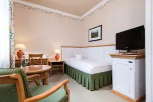 Eenpersoonskamer aja Nordperd & Villa's Göhren Een kamer met een bed en een televisie.