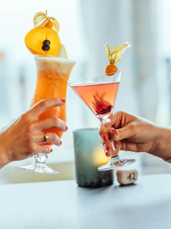 Cocktails Een paar handen houden glazen met drankjes vast.