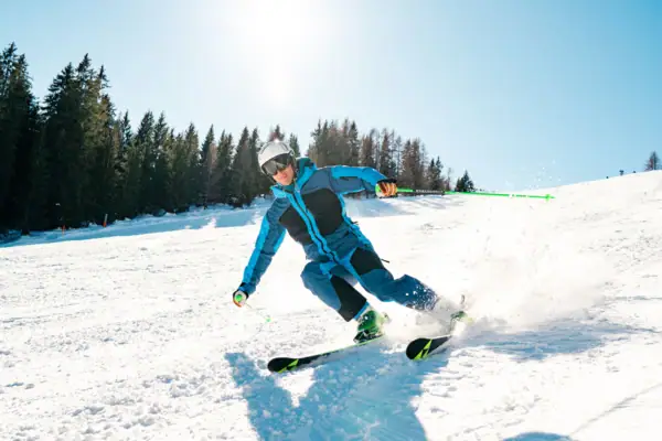 Skiën Iemand skiet een besneeuwde helling af.