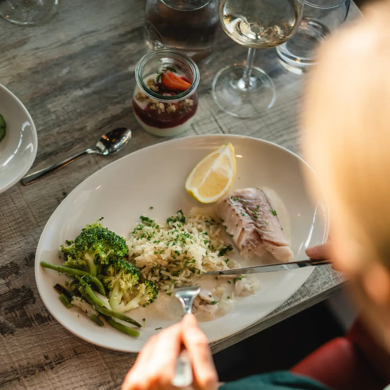 Visgerecht Iemand eet van een bord met eten.