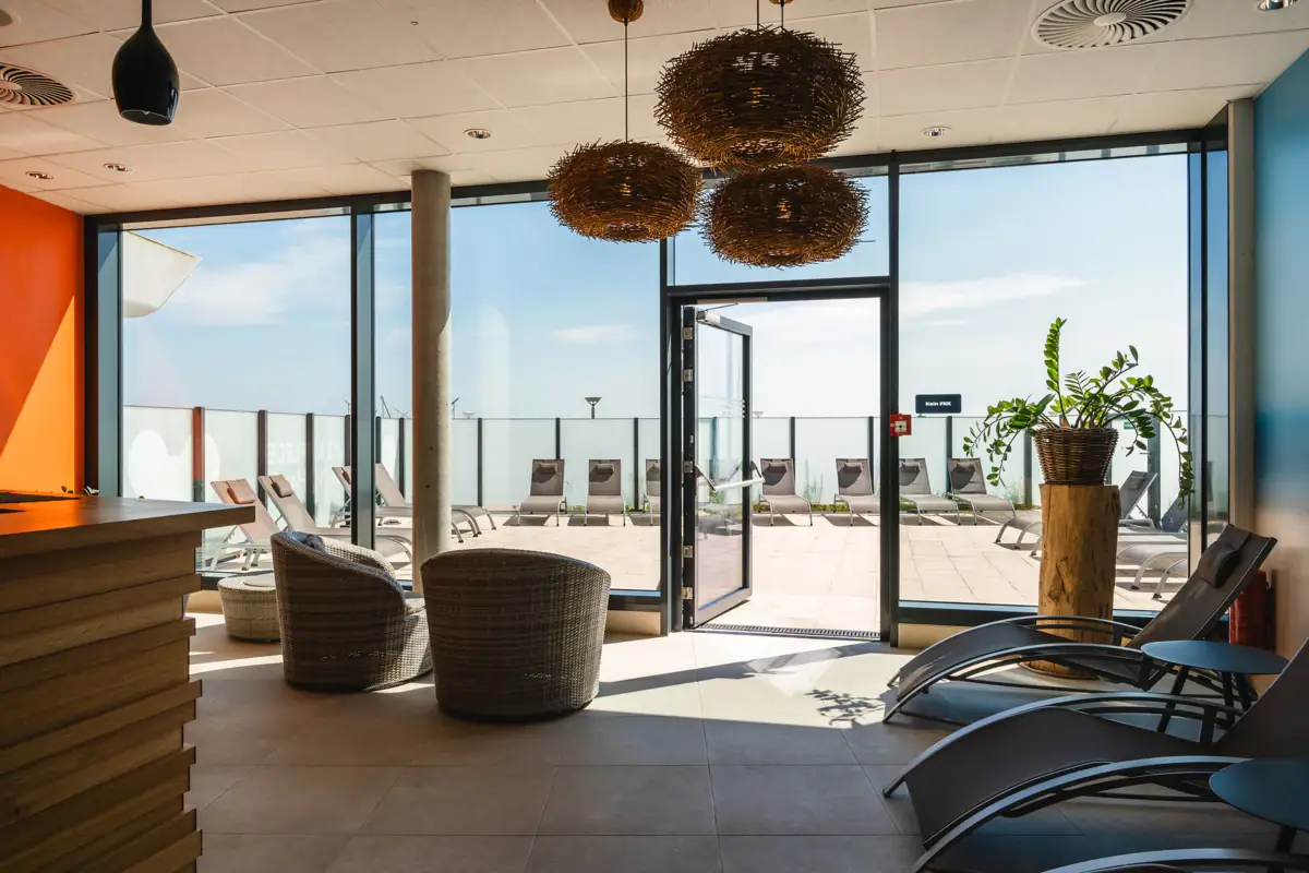 Een kamer met stoelen en een glazen deur.