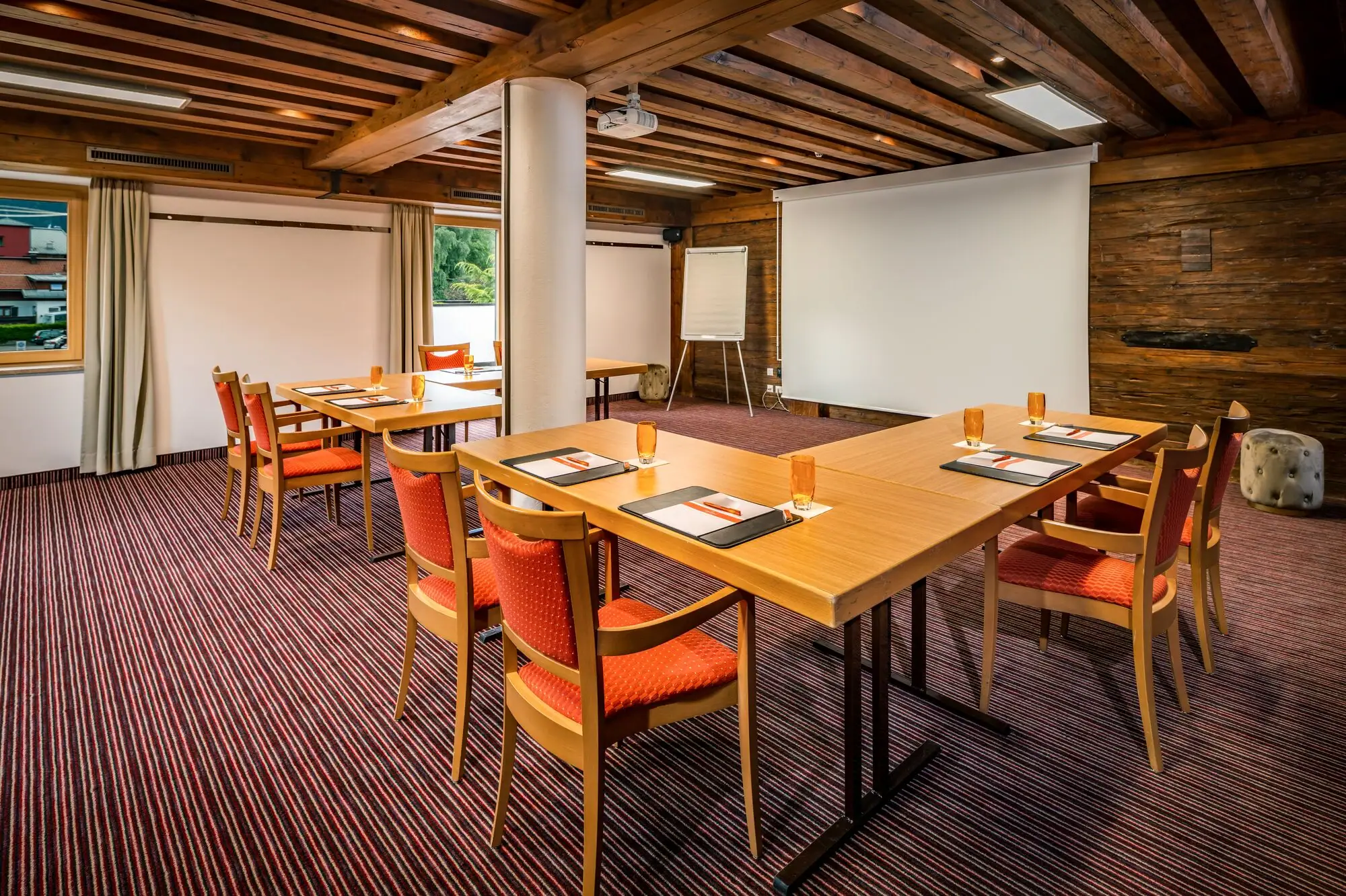 Kamer Benedikt Een kamer met een tafel en stoelen.