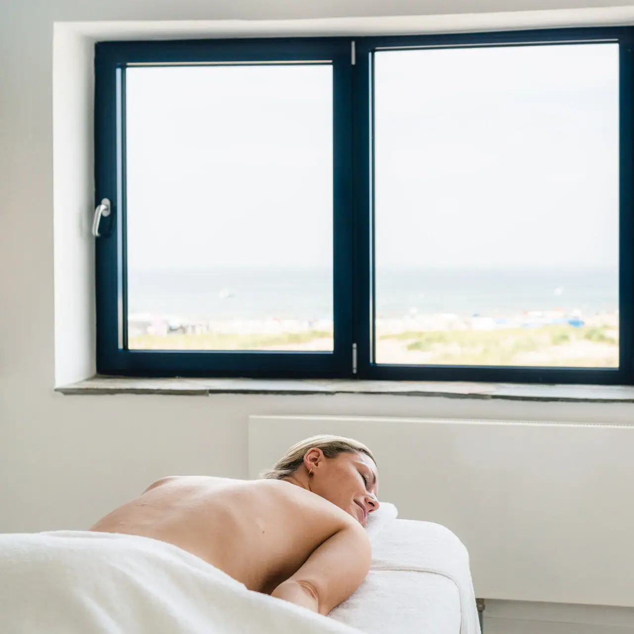 Een vrouw ligt op een massagetafel.