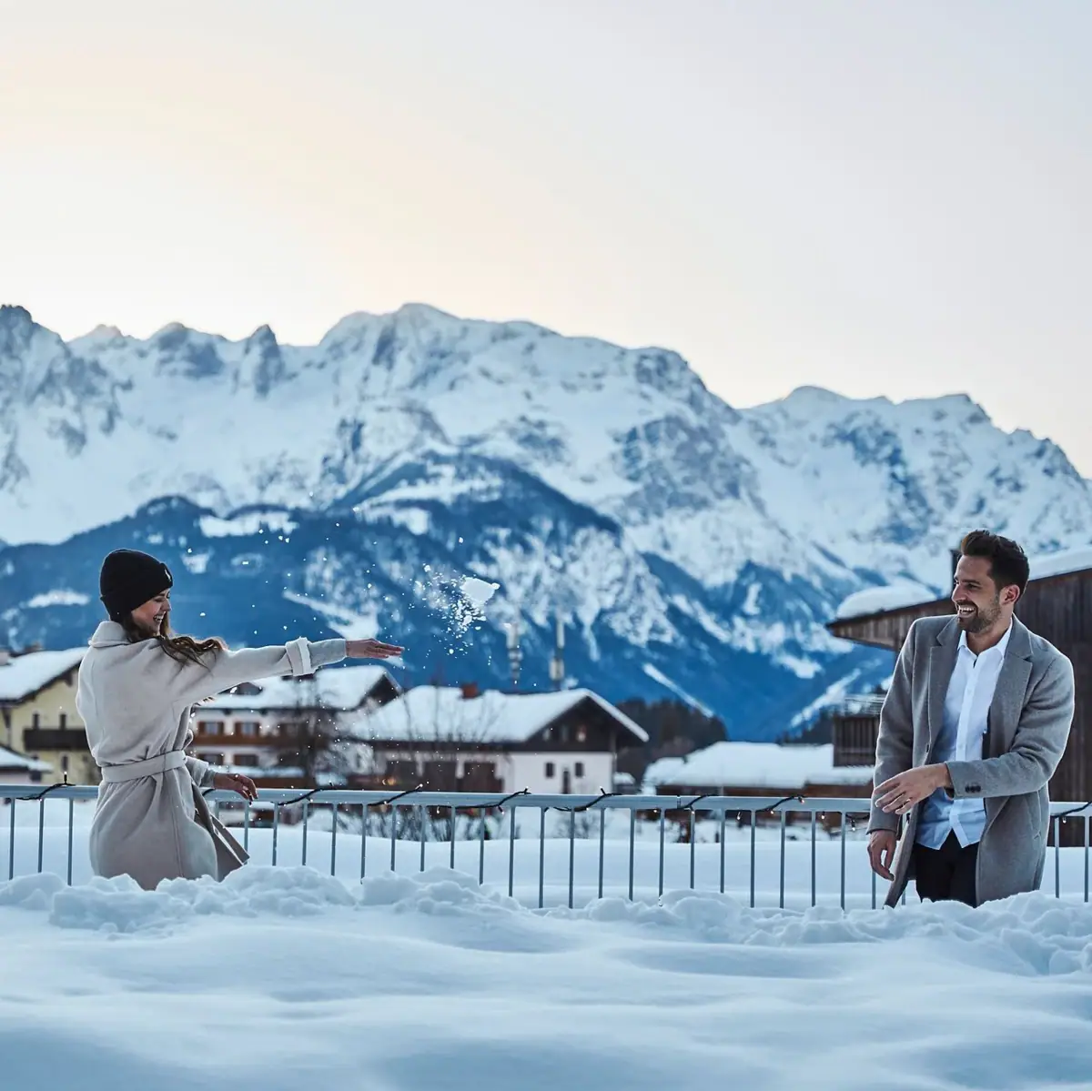 Een vrouw in een witte jas in de sneeuw.