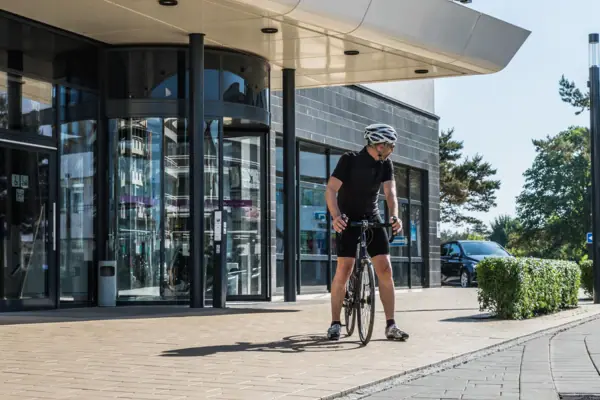 Een man op een fiets voor een gebouw.