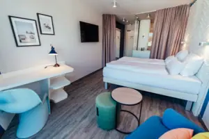 Een kamer met een bed, een tafel en een stoel.