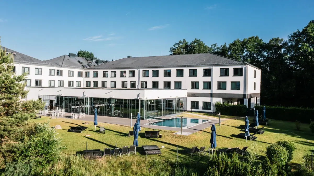 Dag SPA in Bad Saarow Een gebouw met een zwembad en buitenstoelen.