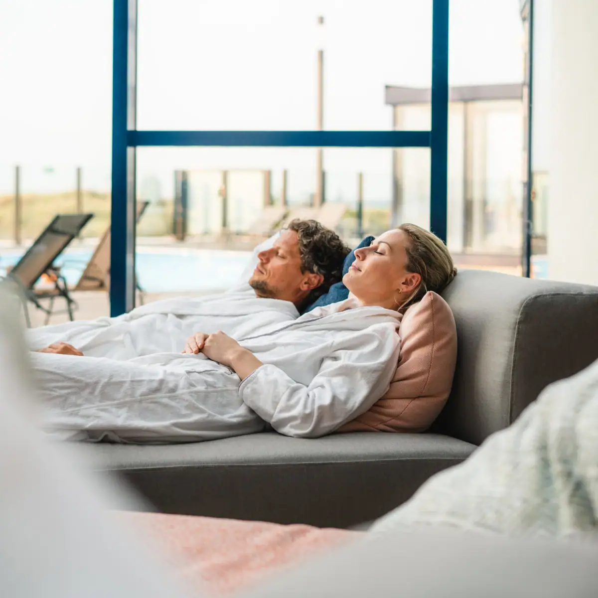 Een man en een vrouw zitten ontspannen op een bank.