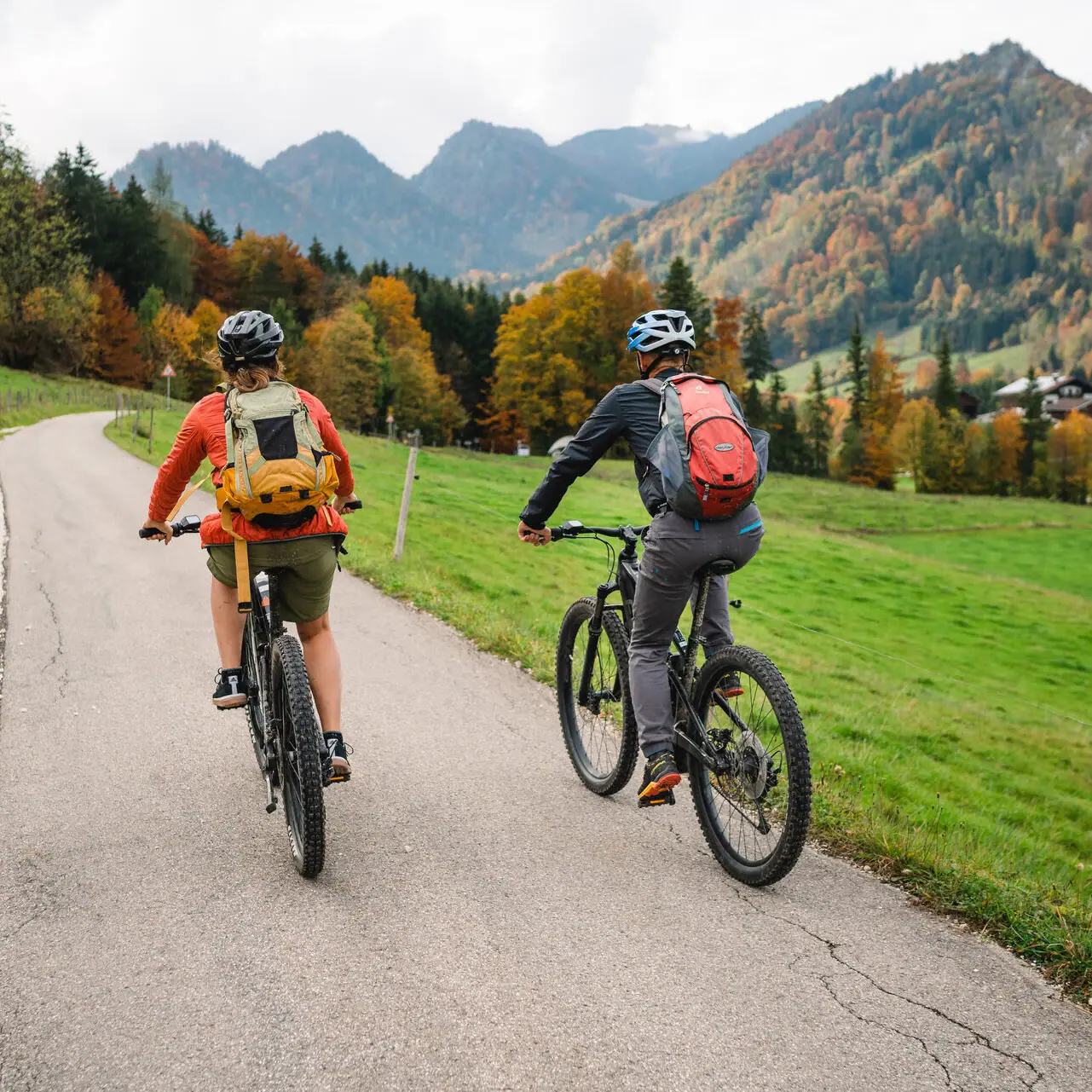 Twee mensen fietsen op een weg in Ruhpolding.