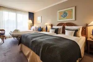 Tweepersoonskamer Een slaapkamer met twee eenpersoonsbedden en een groot bed.