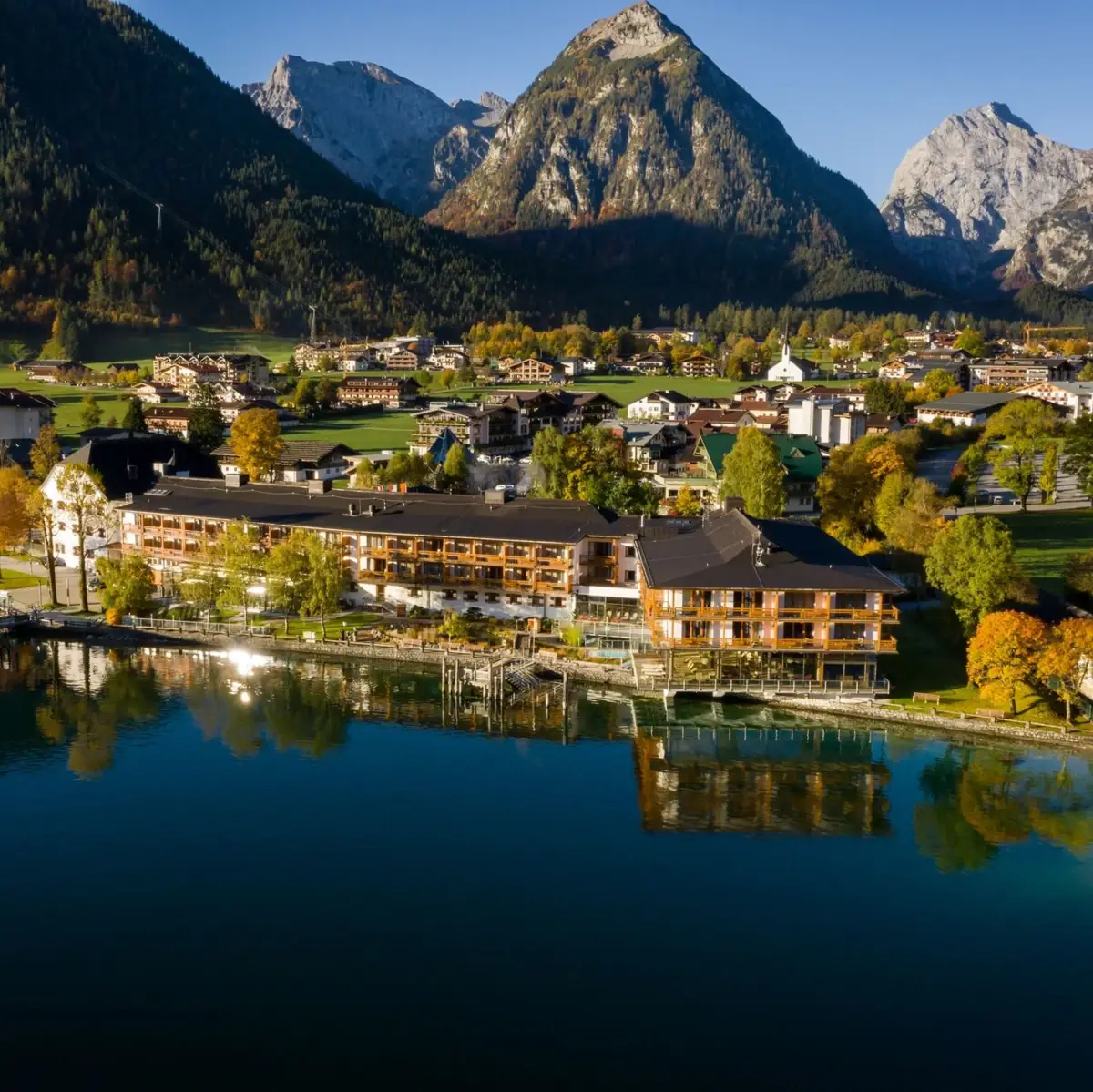 Prinselijk huis in de herfst Stad aan het water met bomen en een heldere hemel.