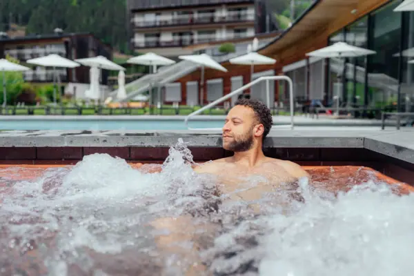 Een man in een buitenjacuzzi.
