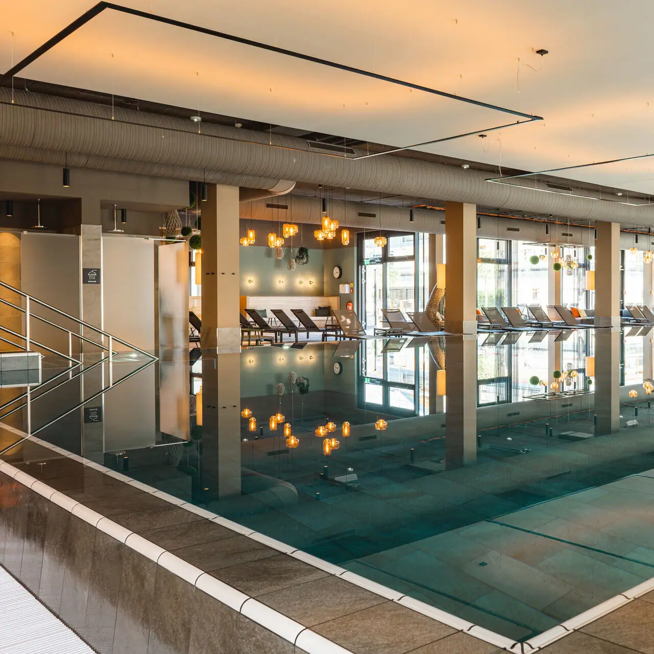 Overdekt zwembad Een groot binnenzwembad met stoelen en een persoon die in het midden staat.