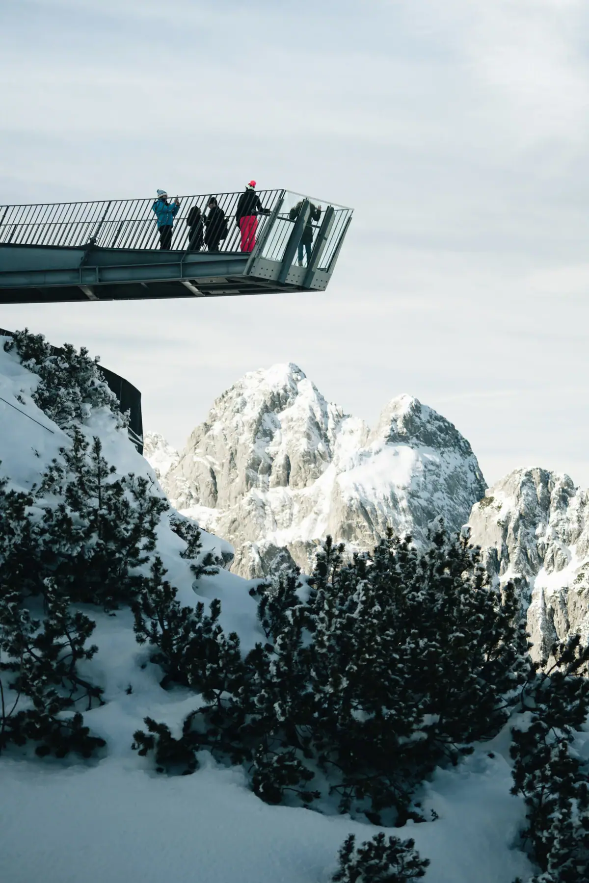 Begeleide wandeltochten Mensen staan op een brug over een besneeuwde berg.