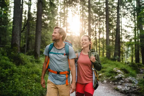 Panorama op de bergen Een man en een vrouw lopen door een bos.
