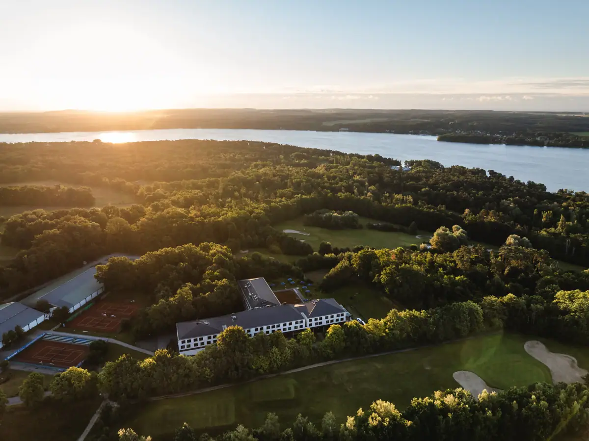 aja Bad Saarow Groot watergebied met een gebouw en bomen op de voorgrond.