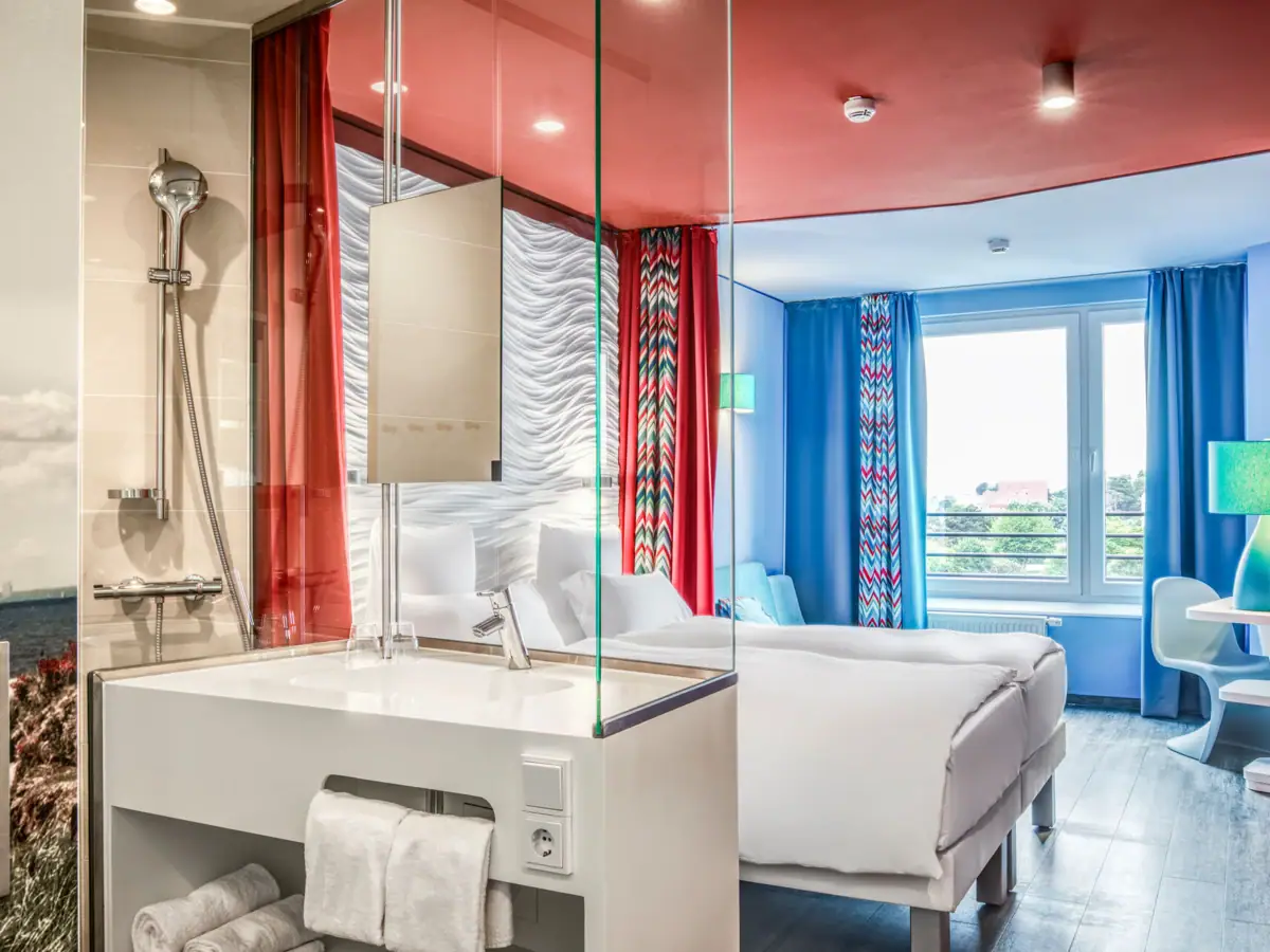 Een kamer met een tweepersoonsbed en een wastafel.