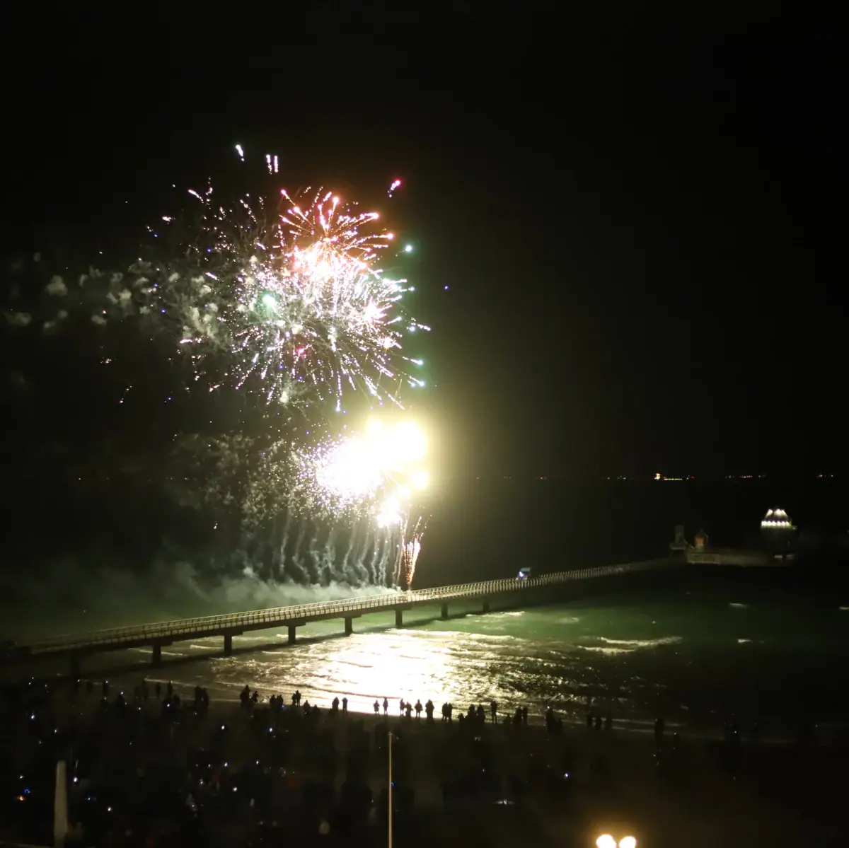 Vuurwerk boven het water aan de nachtelijke hemel