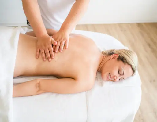 Een vrouw ligt op een massagetafel.