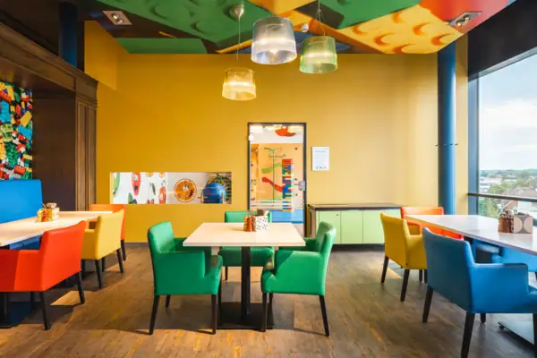 Een kamer met kleurrijke stoelen en tafels.