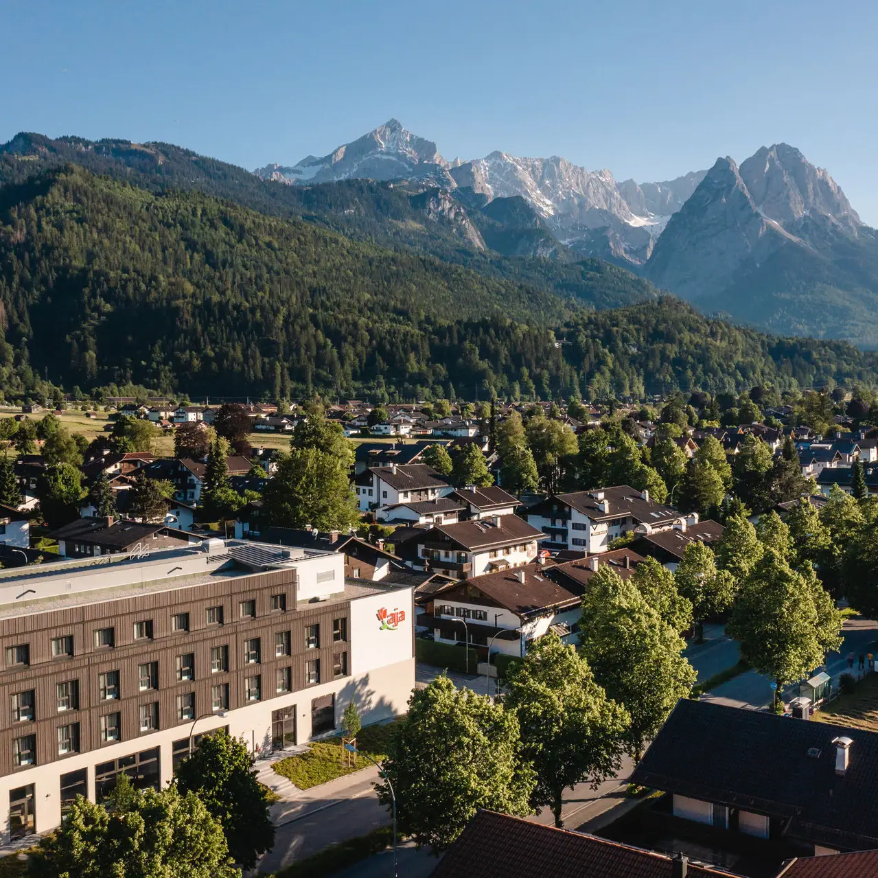 aja Garmisch-Partenkirchen Een stad met bomen en bergen op de achtergrond.
