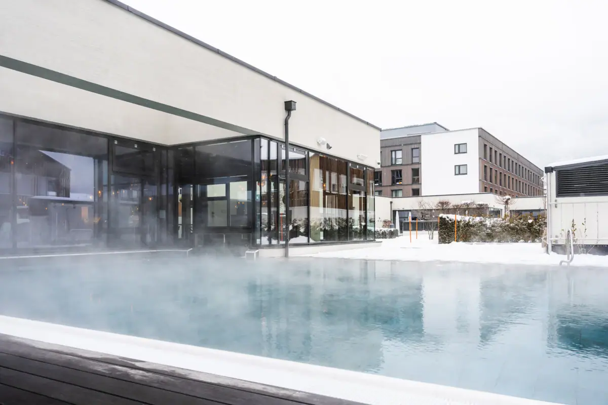Buitenzwembad Een dampend buitenzwembad onder een heldere hemel.