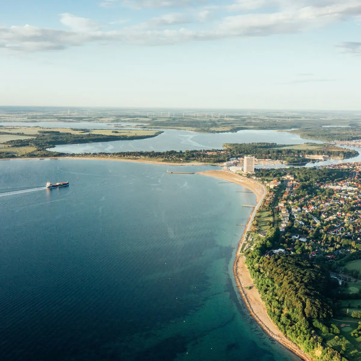Luchtfoto van de Oostzeeregio Travemünde en een kustplaats onder een bewolkte hemel.