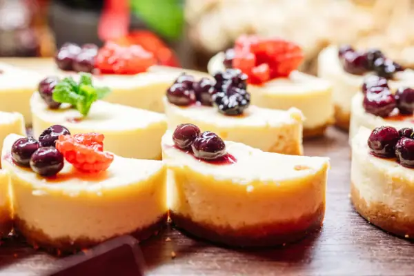 Een groep kleine cheesecakes met bessen erop.