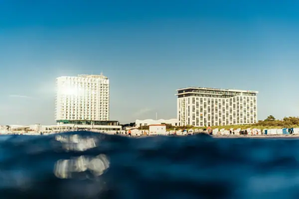 aja Warnemünde Ein Gewässer mit dem aja Warnemünde im Hintergrund.