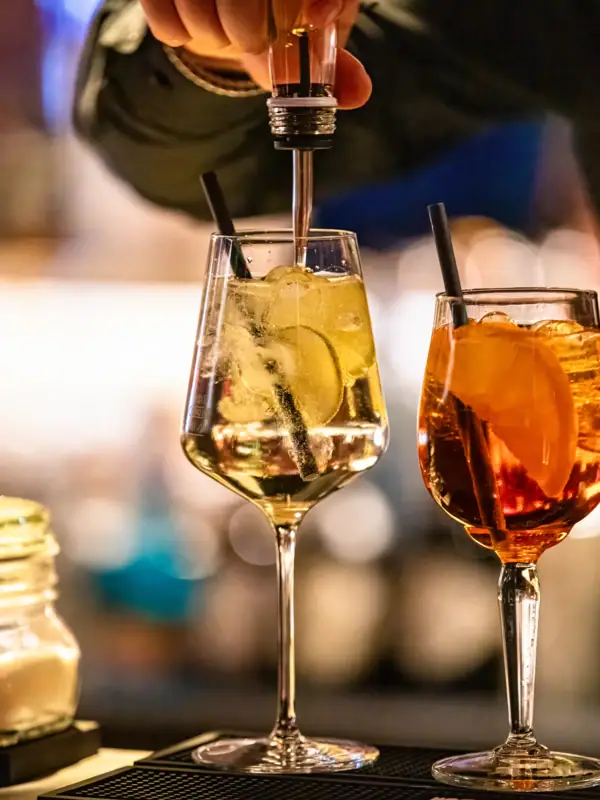 Iemand schenkt een drankje in een glas.