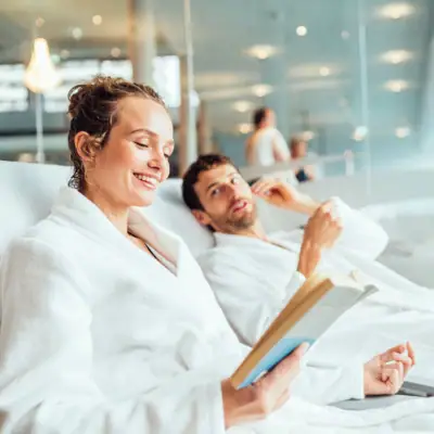 Een man en een vrouw in badjassen lezen een boek.