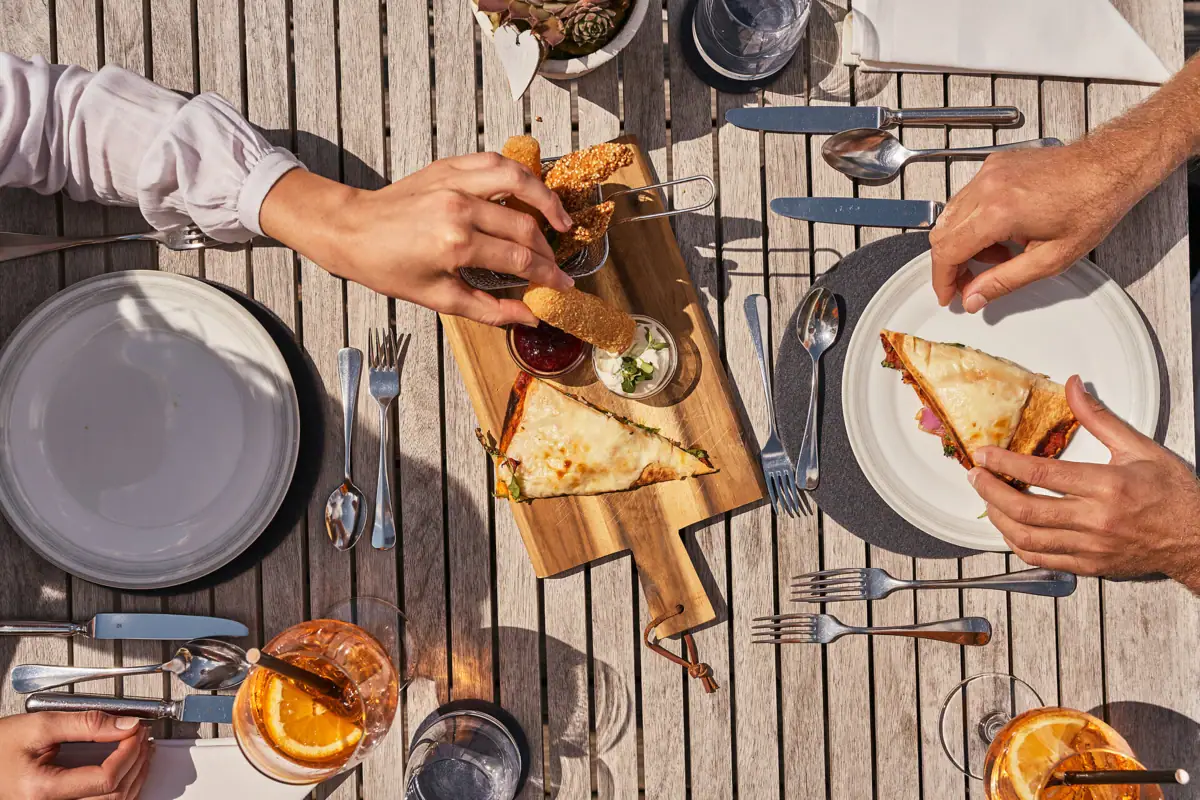 Iemand eet fastfood aan een tafel.