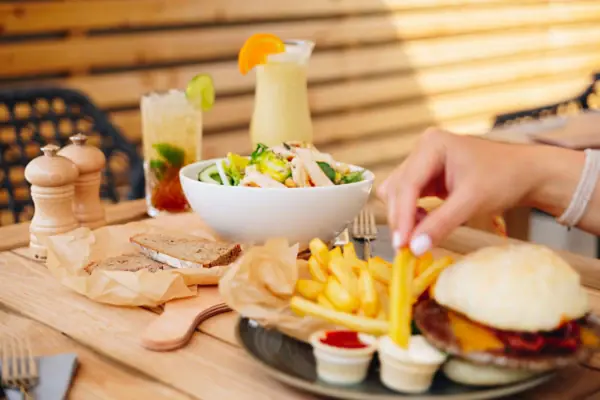 Barfood Garmisch Een salade en een bord met een hamburger en frietjes staan op een tafel in de aja Bar Garmisch-Partenkirchen.
