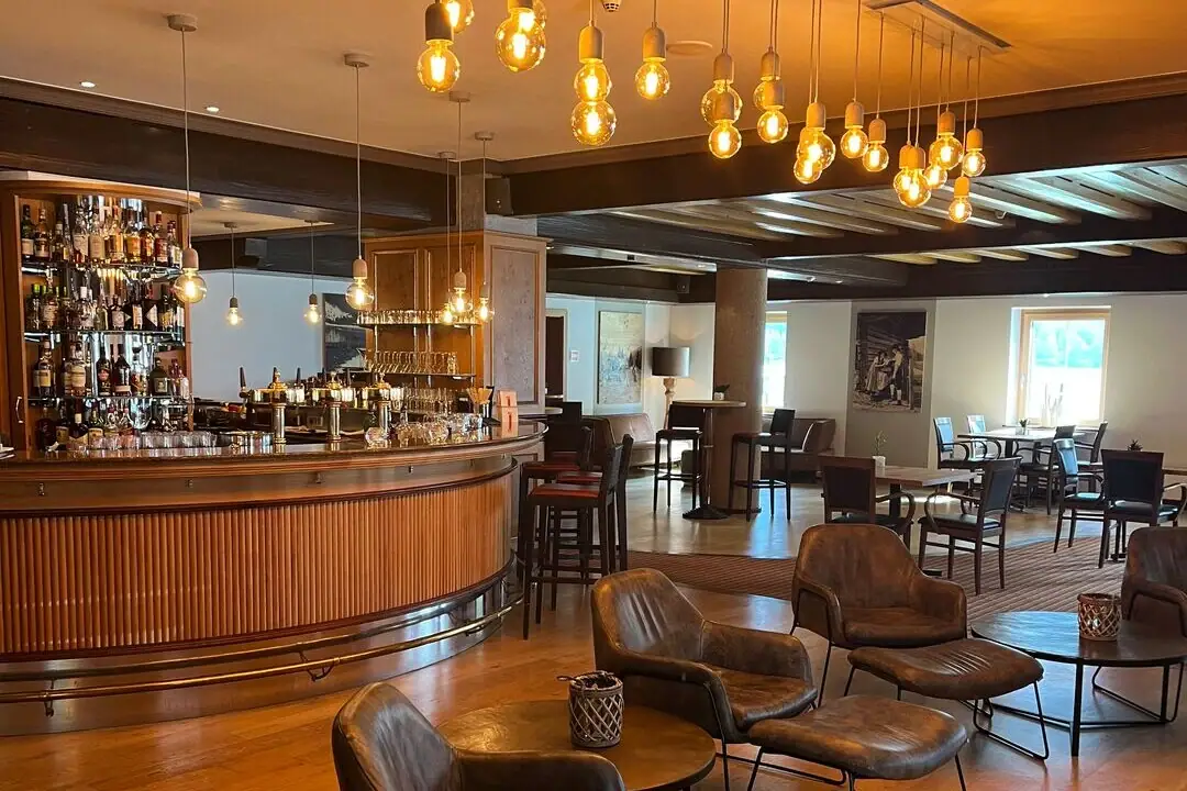 Een kamer met een bar en stoelen.