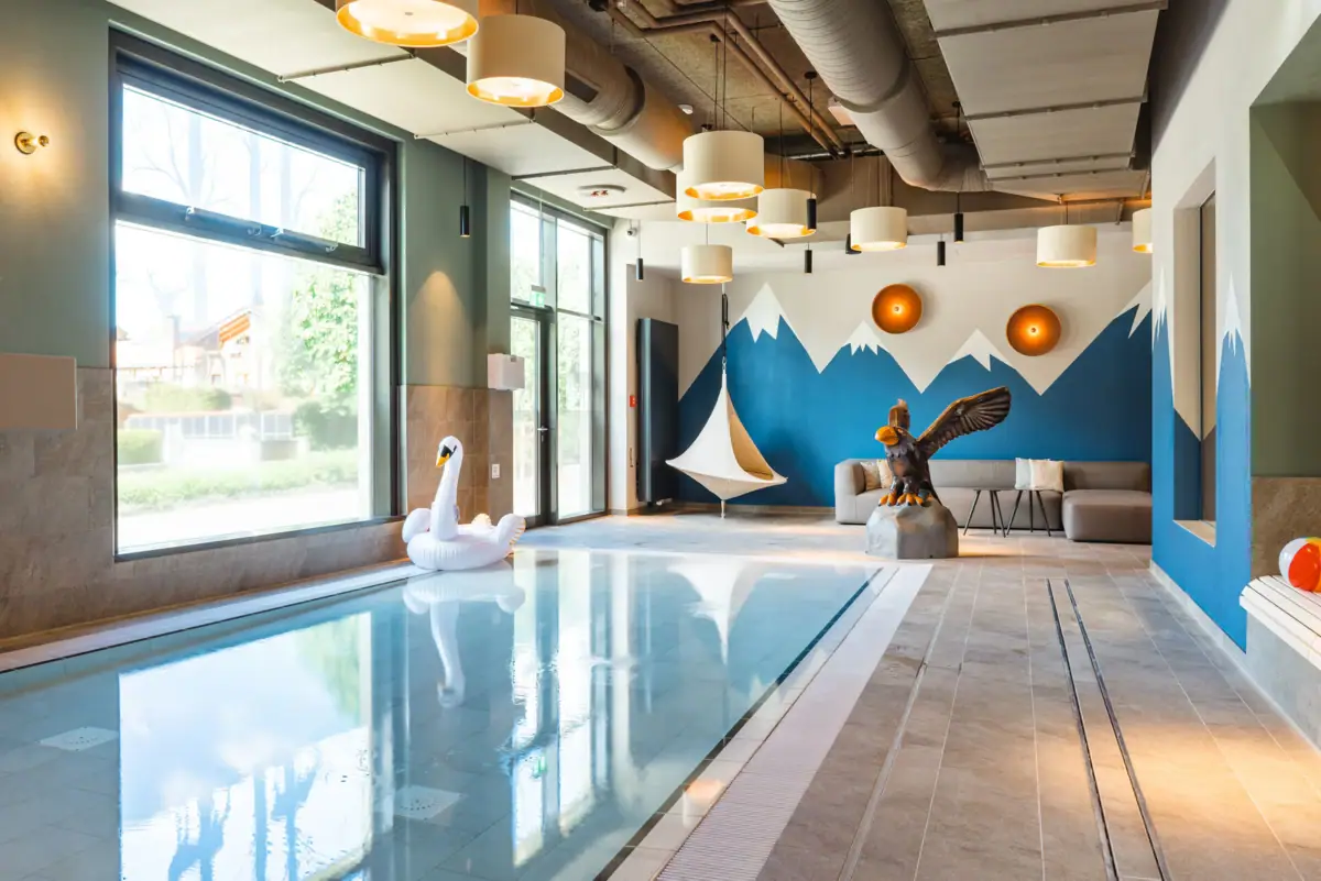 Een zwembad met een zwaan en een vogelsculptuur.