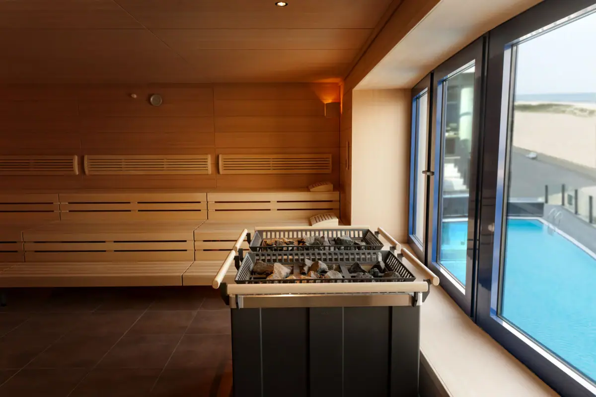 Sauna Een sauna met een raam waardoor je een zwembad kunt zien.