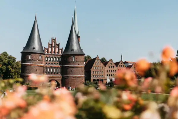 Een gebouw met torens en een grasveld op de achtergrond.