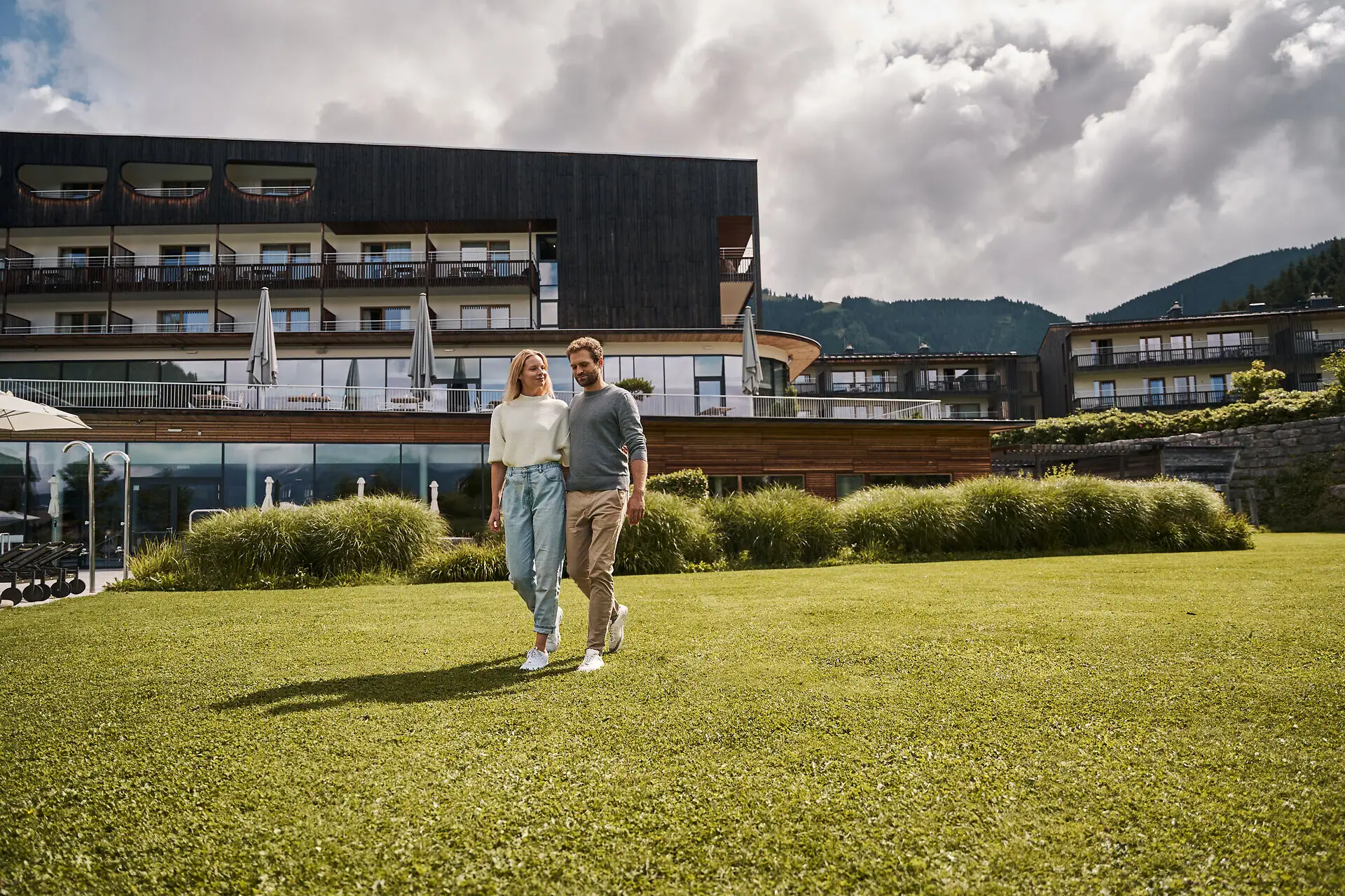 Een man en een vrouw lopen over een grasveld.