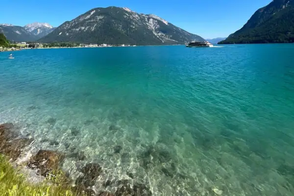 Achensee Meer Een watermassa met bergen op de achtergrond.