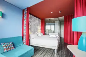 Een kamer met een bed en een blauwe bank.