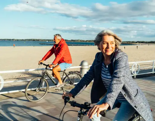 Fietsen Een man en een vrouw fietsen langs het strand.
