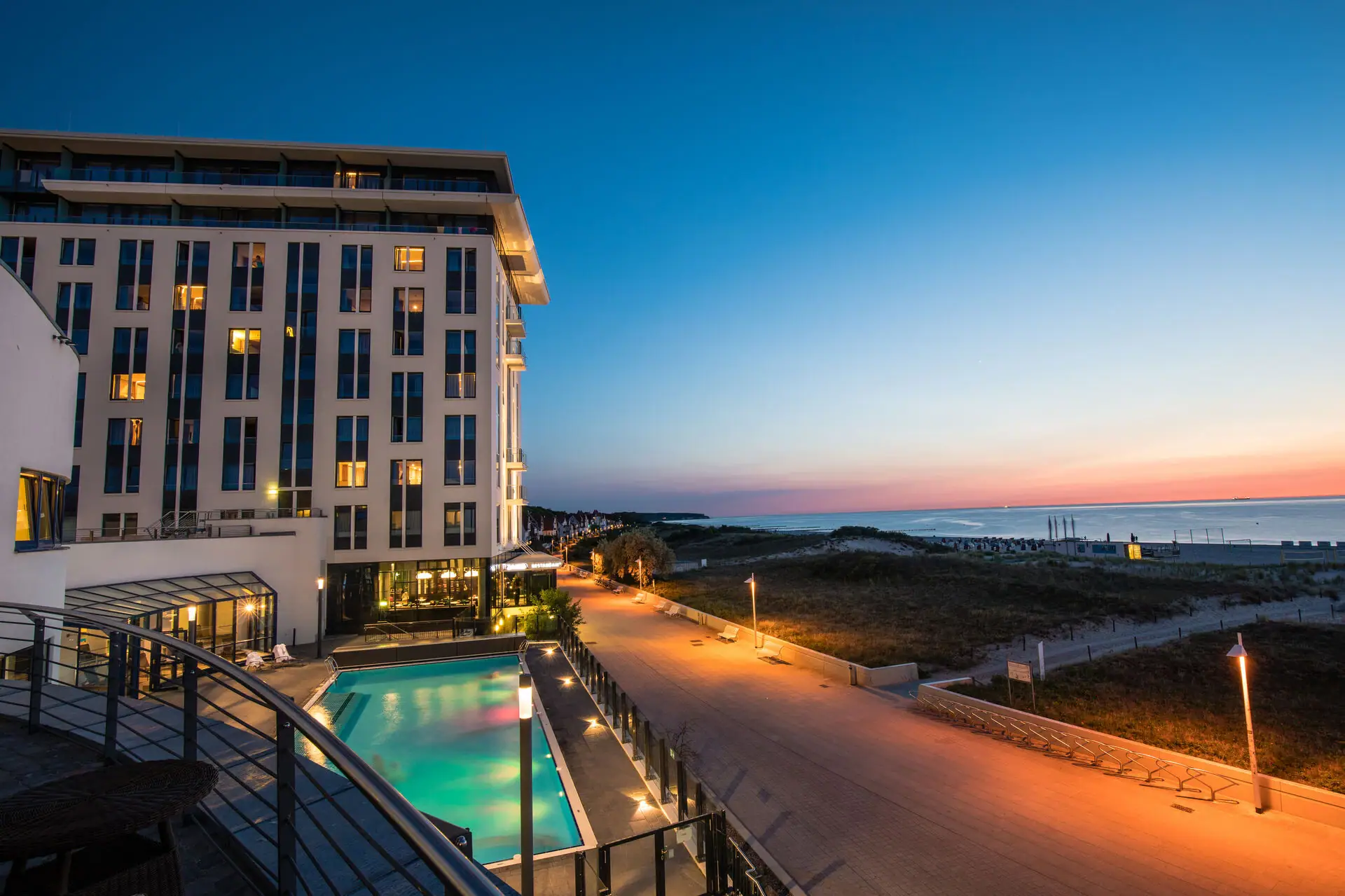 Wellness hotel aja Warnemünde Het hotel met het buitenzwembad en een wandelpad langs de Baltische Zee.