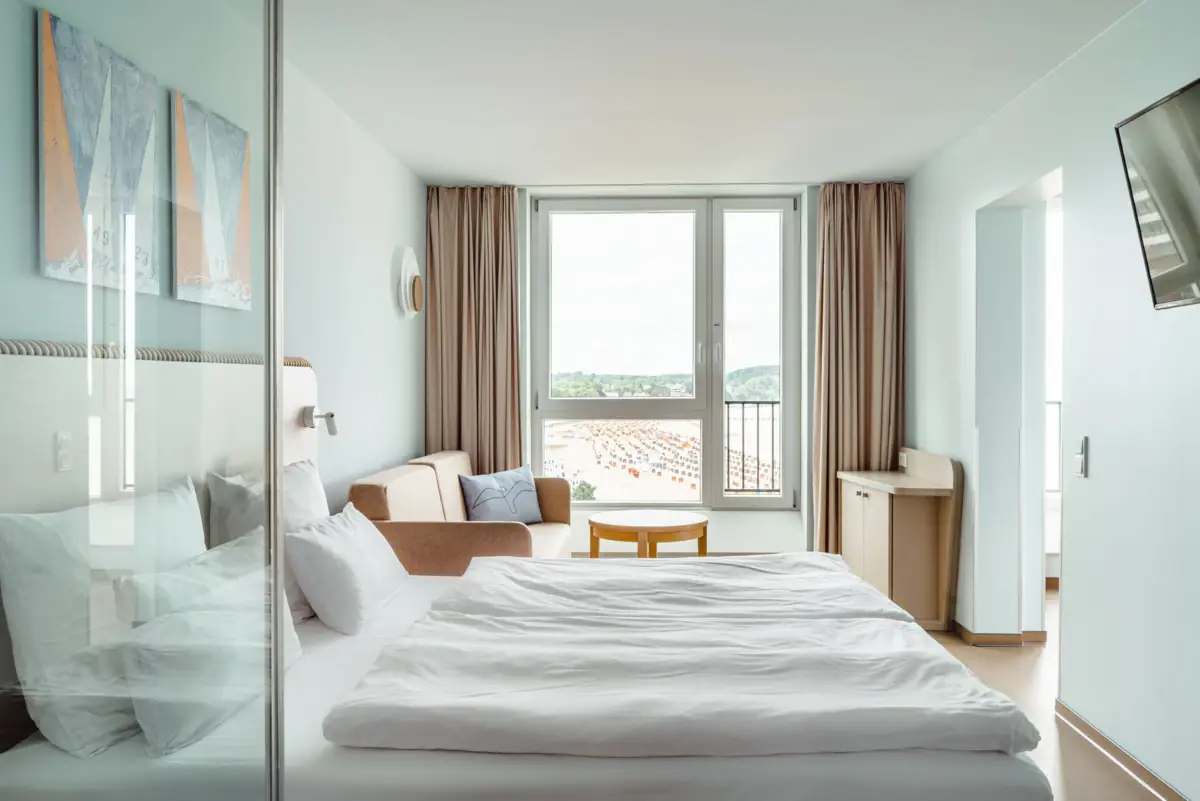 aja Travemünde Kamers Een kamer met een bed, een stoel en een tafel.