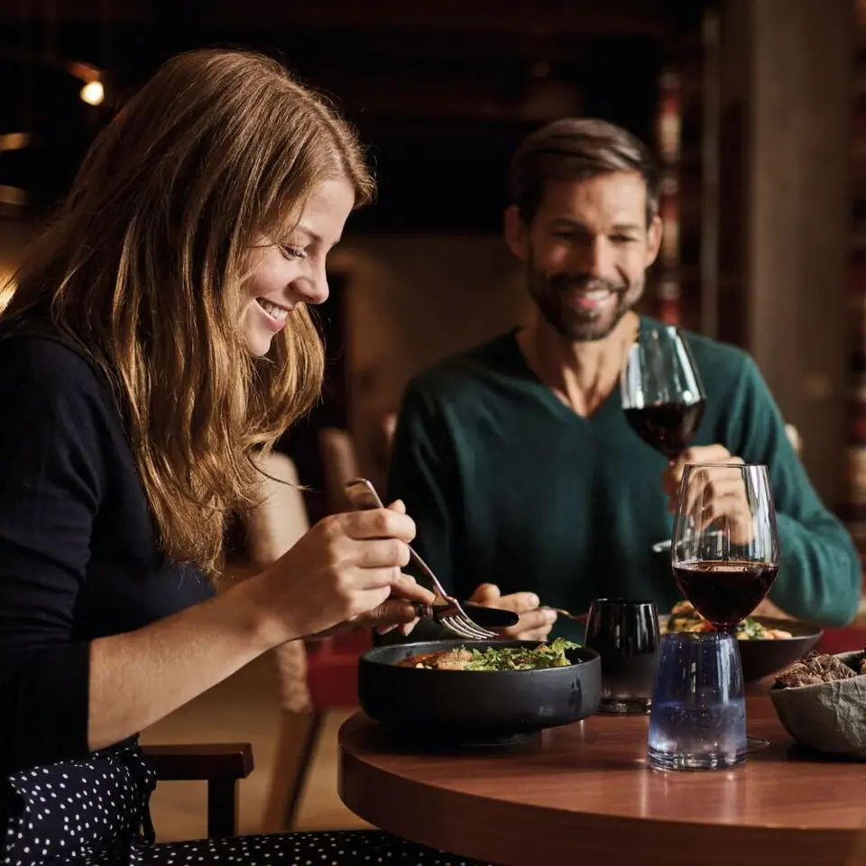 Een man en een vrouw eten aan een tafel.