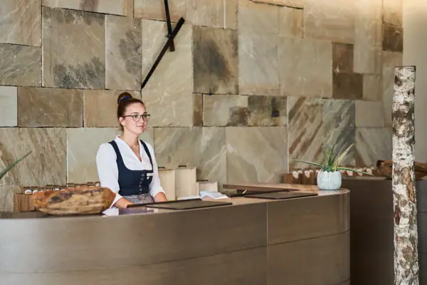 Receptie Een vrouw staat achter een toonbank.