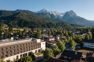 aja Garmisch-Partenkirchen Eine Stadt mit Bäumen und Bergen im Hintergrund.