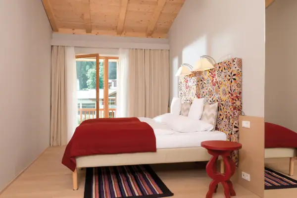 Ein Bett mit einem farbenfrohen Kopfteil in einem Zimmer.