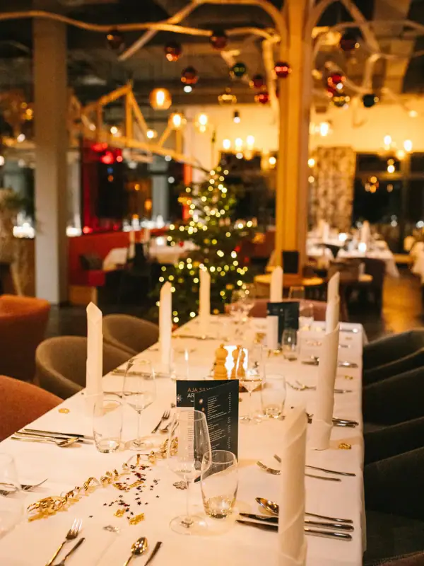 Een feestelijk gedekte tafel met glazen en kaarsen.