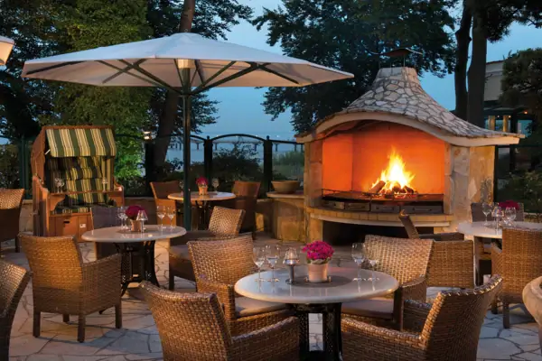 Een tafel en stoelen rond een open haard.